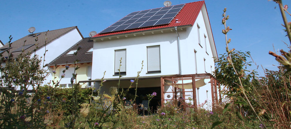 Privathäuser mit Klimaanpassungsmaßnahmen: Pergola, Sonnensegel, Verschattung, trockenheitsresistente Wiese 