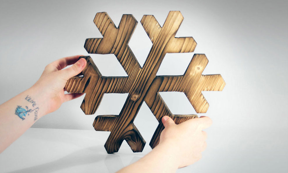 Anker Tattoo am Arm – Hände halten Holz mit einer Schneeflocken-Form