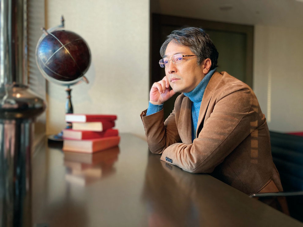 平賀敬一郎建築研究所 代表・建築家の平賀敬一郎。地球儀と書籍を前に、設計の構想を練る思索のポートレート。