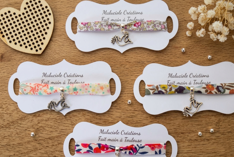 Si vous cherchez un cadeau plus délicat, le bracelet en tissu Liberty est une option idéale. Léger, féminin et intemporel, il peut être agrémenté de breloques symboliques comme :  une croix une colombe