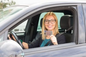 Frau im Auto mit Führerschein
