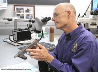 Examen d'une armeà feu par un scientifique