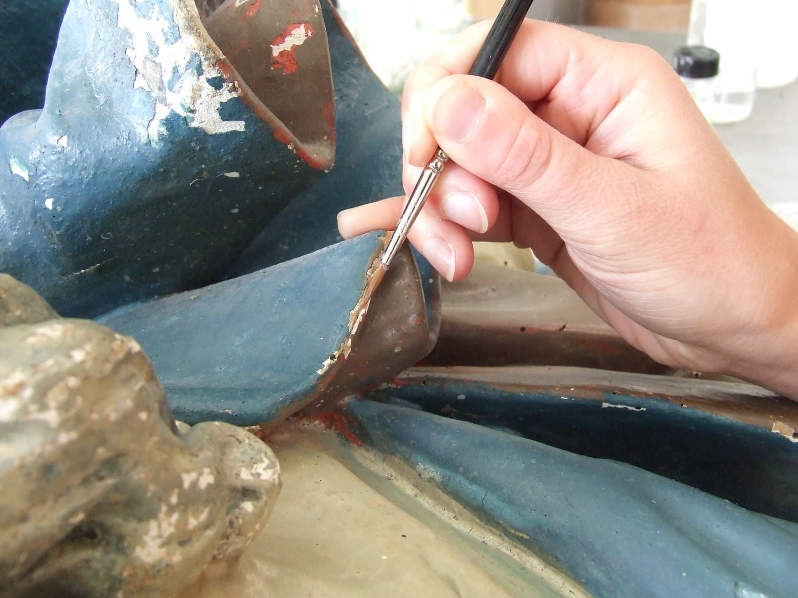 Fixage de polychromie : infiltration au pinceau d'un adhésif sous la peinture