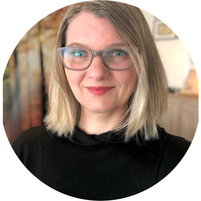 Eine Frau mit glattem blondem Haar und schwarzem Oberteil.