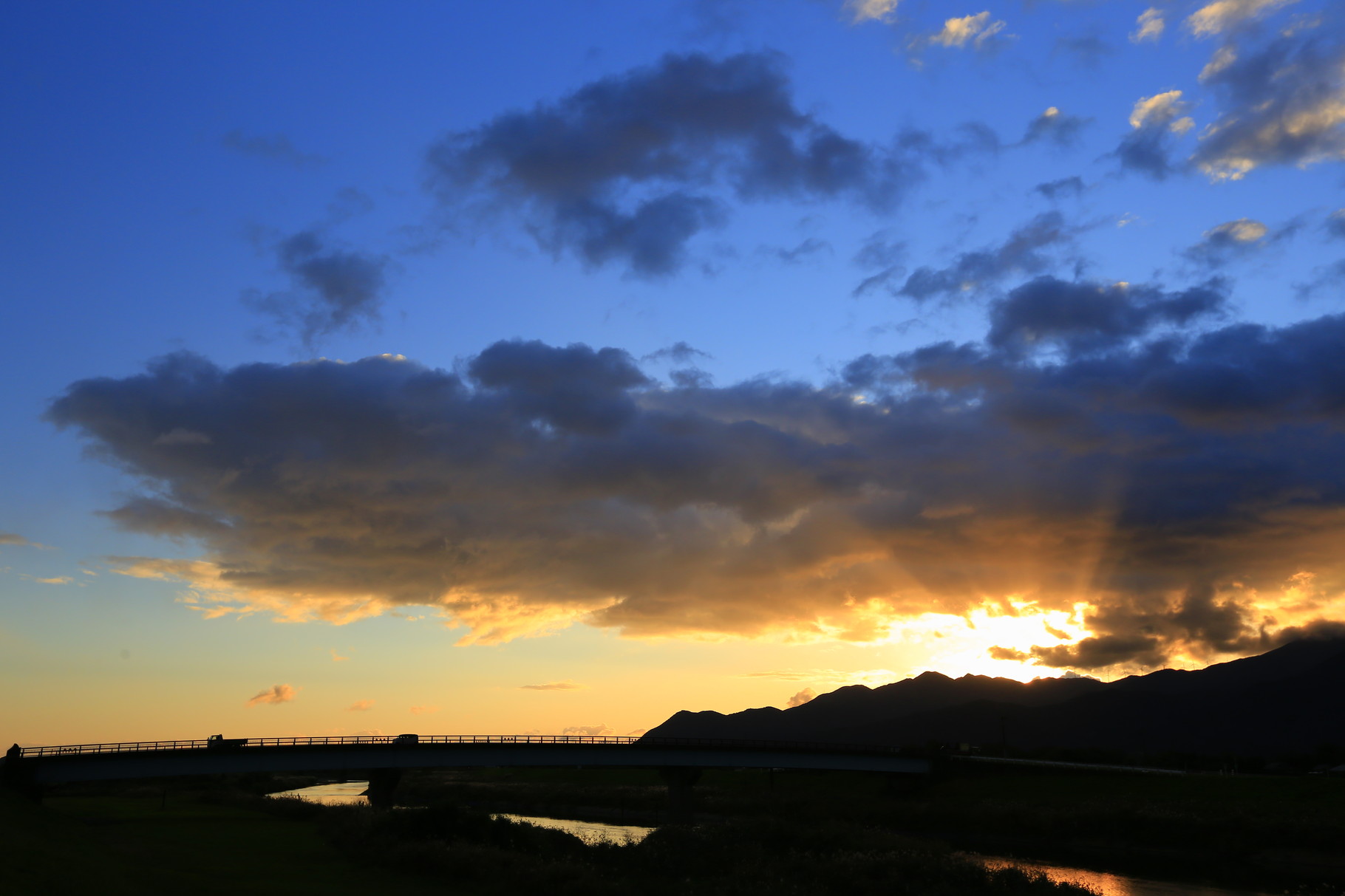 朝の高良橋と光芒を放つ空（山佐木材横の堤防から）
