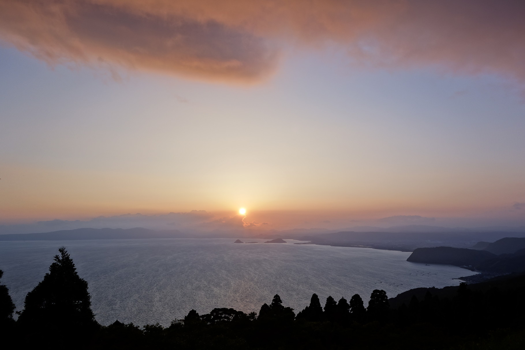 夕焼け雲と夕日。輝北から霧島市沖の無人島「神造島」への眺め。