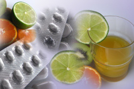 Bild mit gesunden Früchten, einem Glas Saft und Tabletten