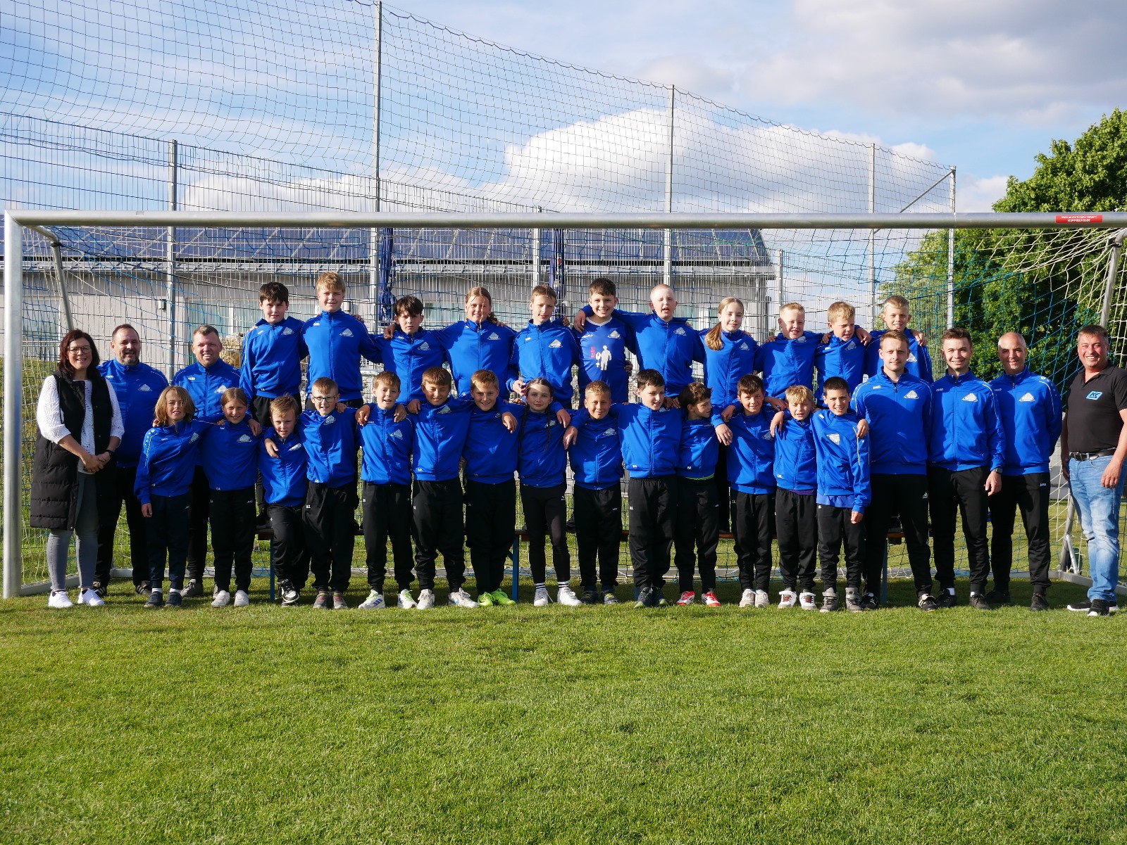 D- und E-Junioren der Saison 24/25 mit den Sponsoren der neuen Anzüge Regina Baldauf vom Malerbetrieb Baldauf und Tobias Schmid vom KS Bauunternehmen und den Trainern Thomas Pfeiffer, Torsten Spyrka, Bastian Gassner, Sami Neumeier und Christian Neumeier