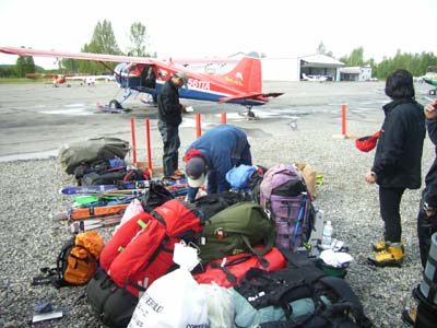 アラスカのタルキートナ飛行場からセスナに乗り込み、雪原のランディング・ポイントまで荷物を運ぶ。