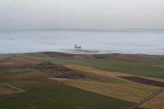 LA IGLESIA DE MALVA DESPUNTA ENTRE LA NIEBLA DEL PAISAJE CASTELLANO