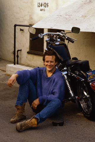 Mickey Rourke accanto una Harley-Davidson sul set di "Nove settimane e mezzo" del 1986 (Los Angeles, California)