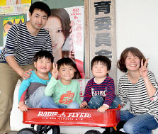 鳩間小学校へ入学する山名元太君(中央)。転入手続きのため、家族で町役場を訪れた=19日午後、町役場