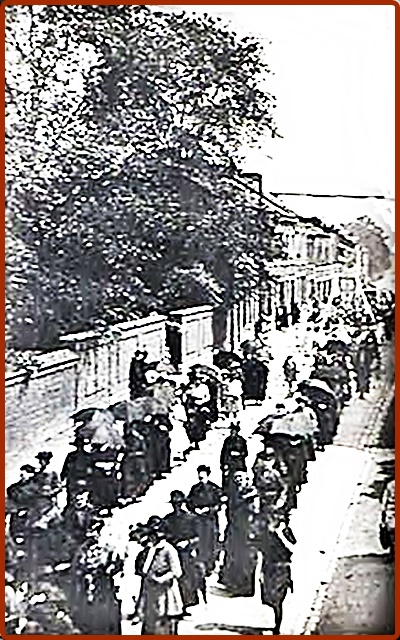 Rue Paquay, le mur de l' école des Six-Bonniers  à gauche, une procession