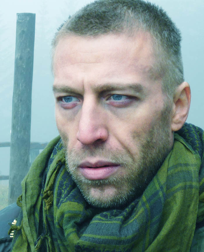 Ottaviano Blitch interpreta Fred in Shadow, attore, primo piano ravvicinato dallo sguardo diretto in atmosfera fredda e cinematografica