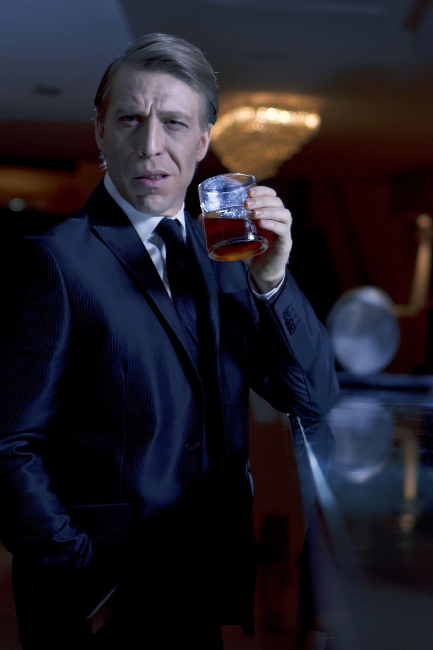 Ottaviano Blitch, Italian actor and performer, moody portrait holding a glass in a dark lounge atmosphere, attore performer italiano ritratto lounge notturno