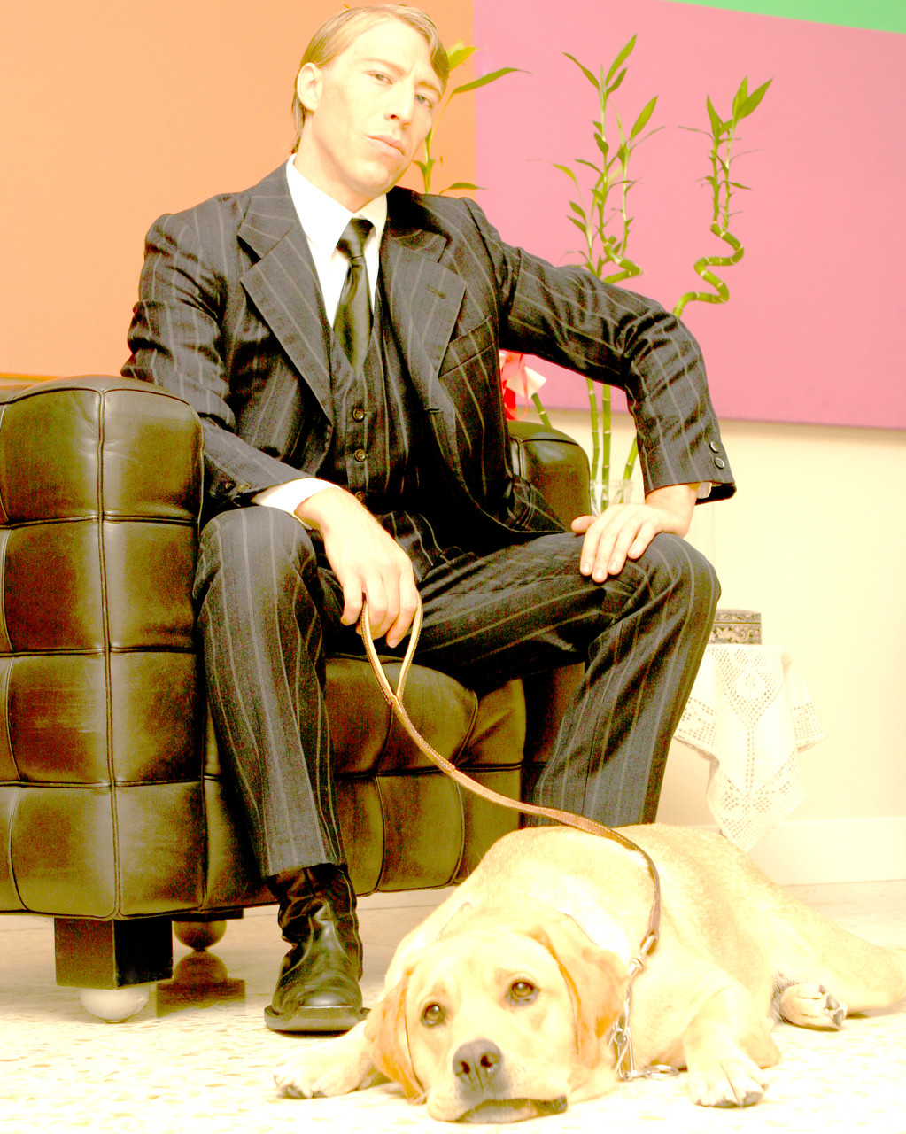Ottaviano Blitch, actor and performer, editorial portrait seated in a leather armchair with a labrador dog, attore performer ritratto editoriale