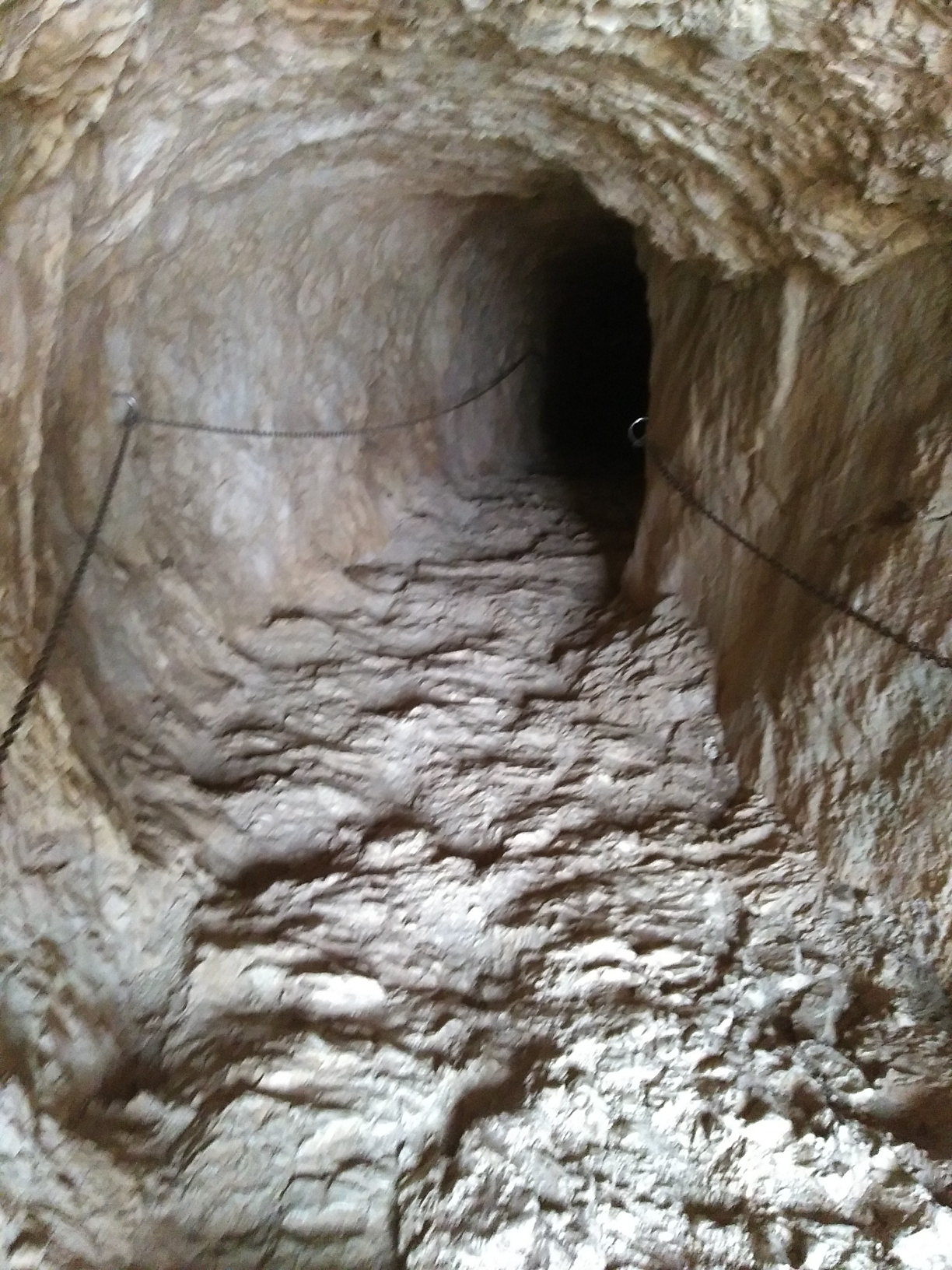 Nach unten ist die Höhle ziemlich steil und rutschig. Gottseidank gibt es Seile an den Wänden