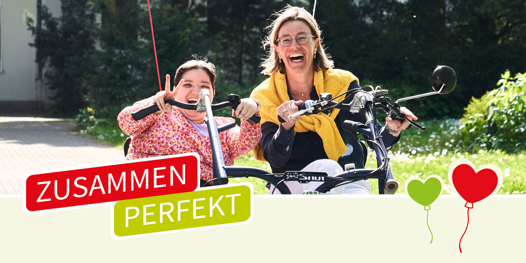 Magdalena mit Luise Gutsche auf dem Mobility Duo Dreirad im Garten des Haus St. Martin