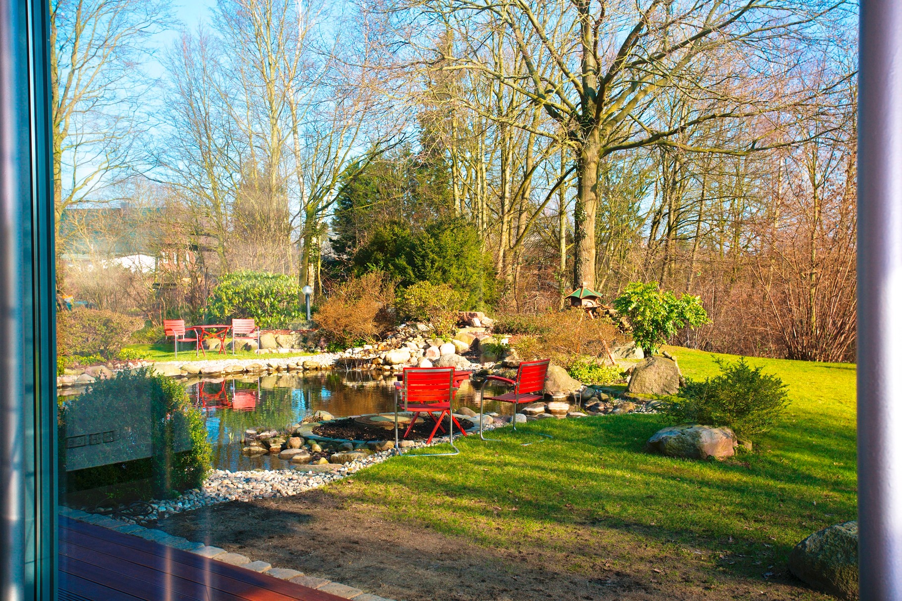 ... mit Blick in den parkähnlich angelegten Garten mit Zierteich