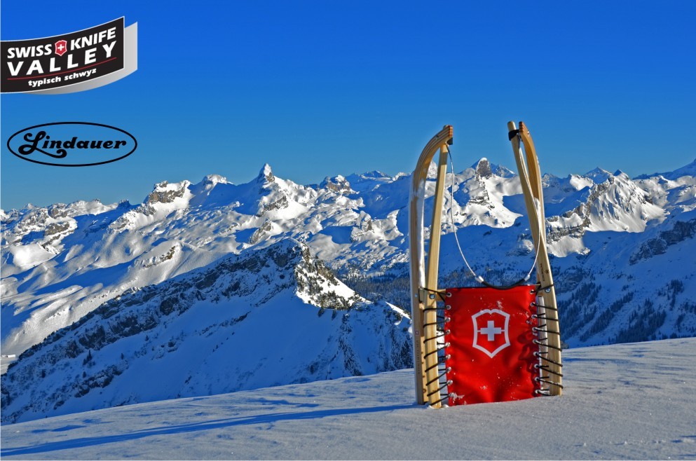 Herrliche Winterkulisse mit verschneiten Bergen und einem Victorinox-Rodel von Lindauer im Schnee