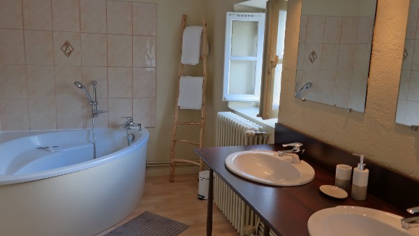 Salle de bains avec baignoire et double lavabo