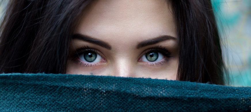 femme avec yeux bleus et sourcils parfaits, echarpe bleue devant la bouche