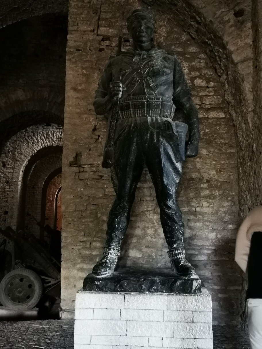 Ein albanischer Partisane. Kämpfte gegen die deutsche Wehrmacht. Wie das mit dem Hitler Fanatiker im Laden zusammenpasst hinterlässt Fragezeichen. 