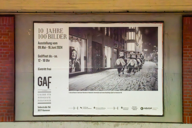 Bernd Reinert "Berittene Polizei nach dem 96-Spiel" auf der Plakatwand in der Station Christuskirche