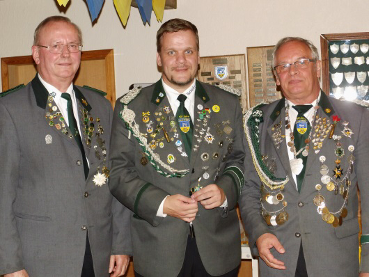 Foto: Amtierender "König der Wilden" Andreas Thiel (Mitte) mit dem Erbauer des Vogels Claus Mehrtens (links) und Sportleiter und Organisator des Vogelschießens Bruno Hensel (rechts).