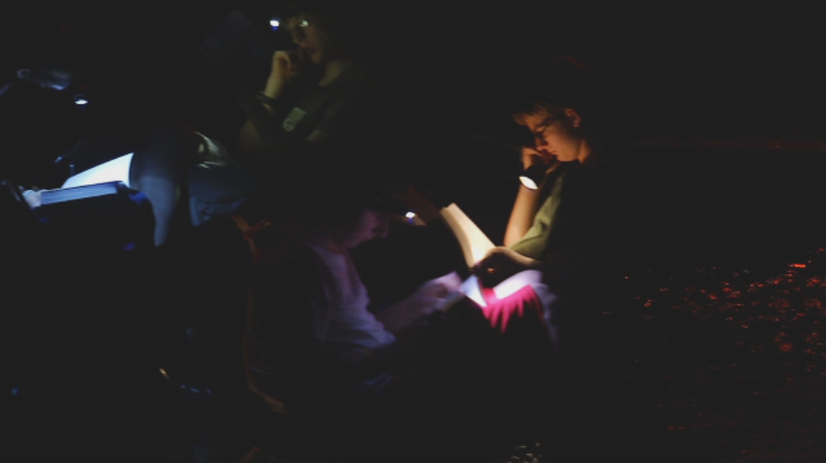 Reading by flashlight while sitting in the river.  © 2013 First Pictures.  All rights reserved.