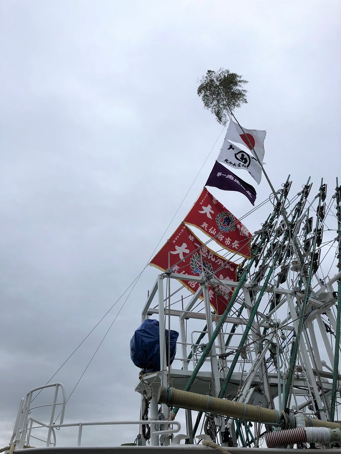 日本国旗、丸中水産旗、第一恵比須丸旗、気仙沼市から贈られた大漁旗をはためかせて。船後方にも頂いた大漁旗など沢山飾ります。