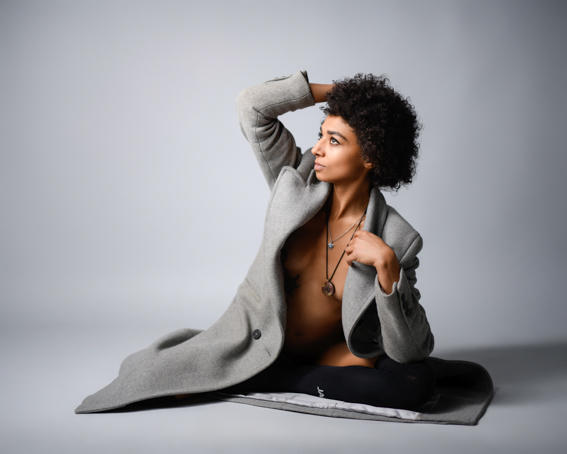Boudoir-Portrait einer Frau im Studio in Villach im Editorial-Stil, sitzend in offenem Mantel