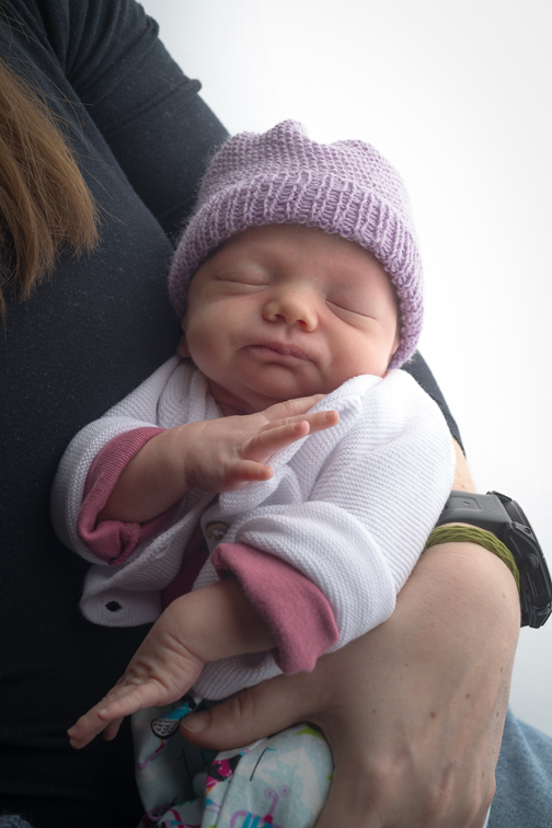 Schlafendes Baby mit Haube, natürliche Babyfotografie im Studio in Villach