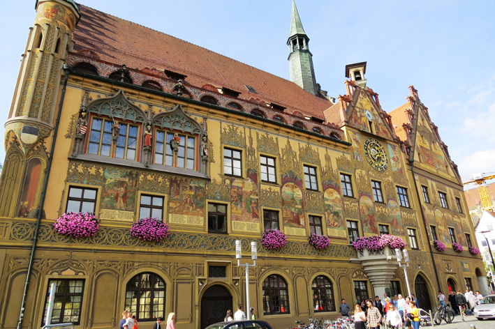Sehenswürdigkeiten Deutschland: Goldgelbe Aussenfassade mit kunstvollen Malereien des Rathauses in Ulm (Baden-Württemberg)