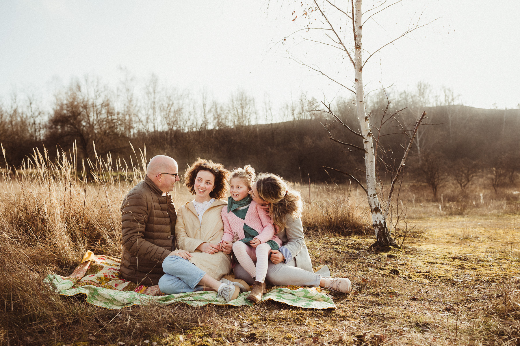 Familie kuschelt auf einer Decke