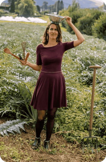 Ariane en robe dans les champs de cardons du GAEC bouquet savoyard avec passoire sur la tête et ustensiles de cuisine dans les mains