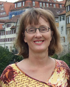 Frau mit halblangen blonden Haaren und Brille, lächelnd, am Neckarufer in Tübingen