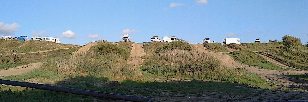 frei stehende Camper über einem Motocross-Übungsgelände. Aber im Dunkeln hört das lautes Treiben wohl auf