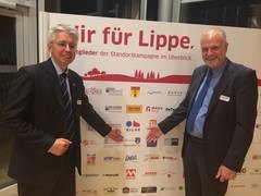 Matthias Engel und Rüdiger Krentz von der Stadt Horn-Bad Meinberg, vor der Tafel mit den Logos der Unterstützer der Standortkampagne.