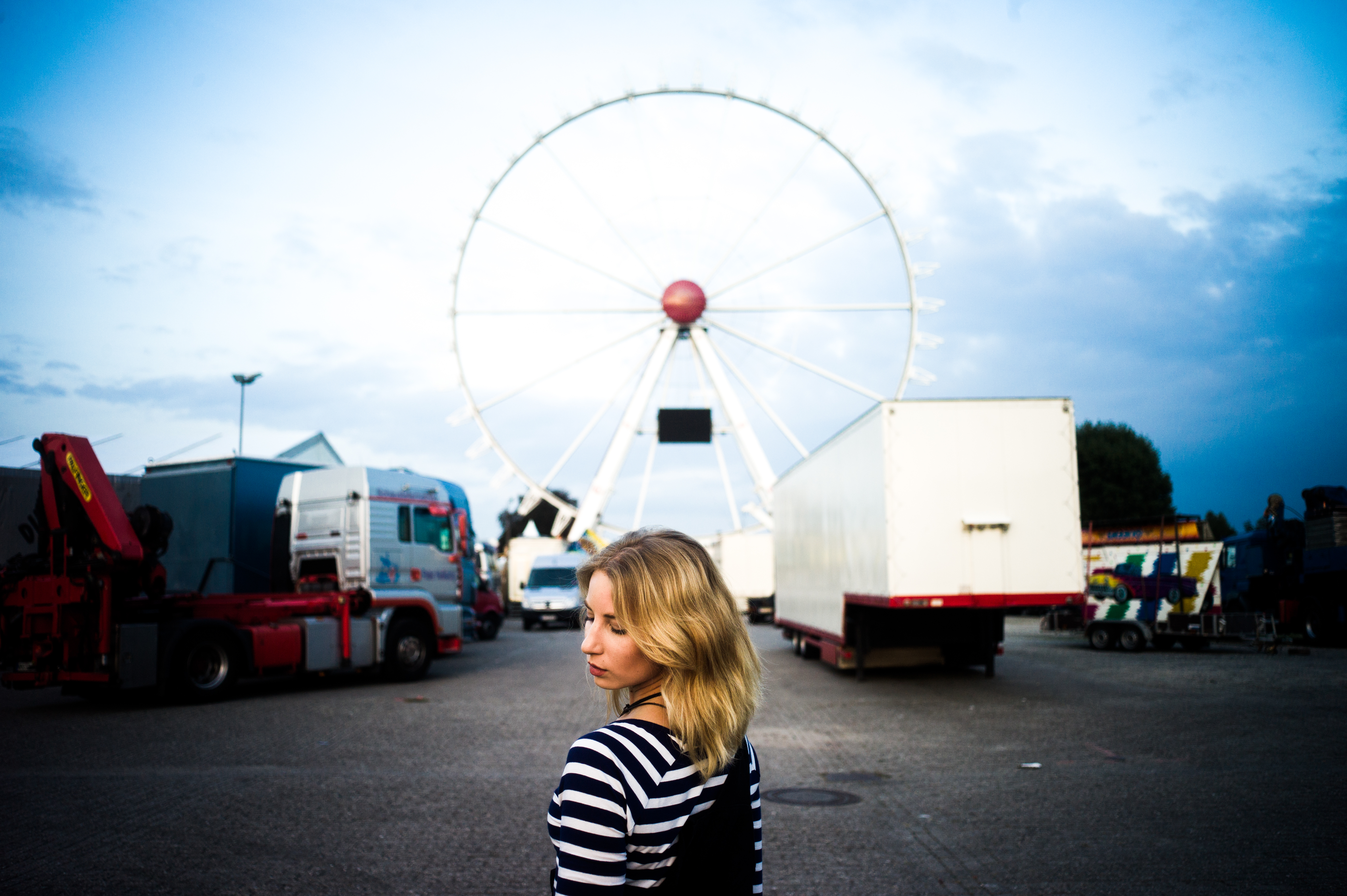 Junge Frau mit Blick nach hinten im Hintergrund großes Riesenrad in Oldenburg