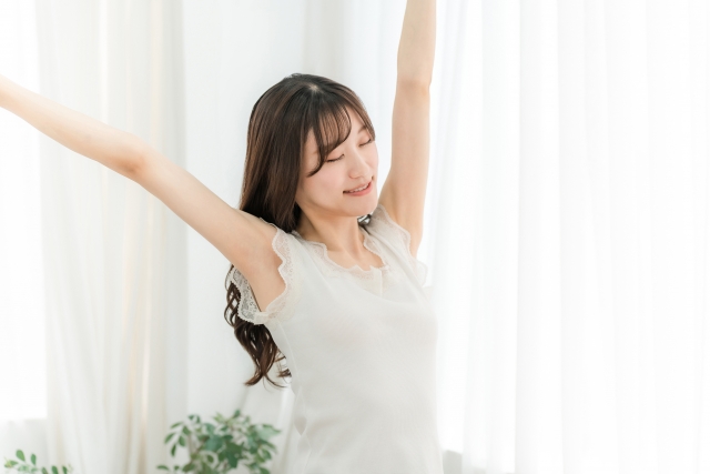 青森市の整体院で施術を受け、リラックスした表情で両手を広げてスッキリとした様子の女性。日々の疲れをリフレッシュし、軽やかな気分を実感している姿