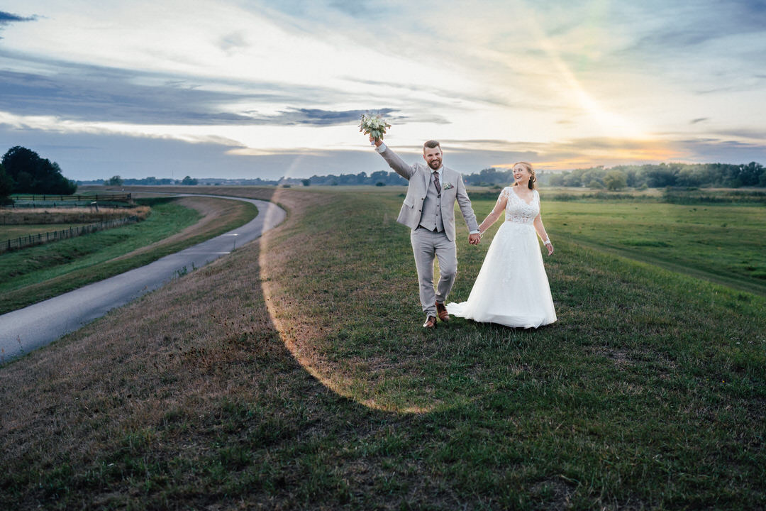 glückliches Brautpaar beim Fotoshooting am Deich bei Marschacht