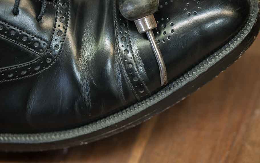 Das Bild zeigt das Hand-Werkzeug, den Stupper, mit dem der Rahmen vor dem Doppeln gestuppt wurde. Bei diesem Schuh ist die Doppelnaht zusätzlich in einem Riss im Rahmen fast nicht sichtbar versenkt.