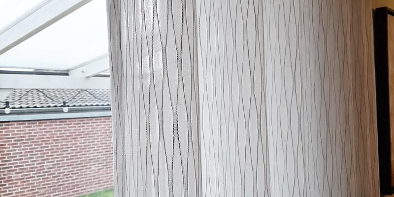 Minimalistische Gardinen mit dezentem Muster im Wohnzimmer