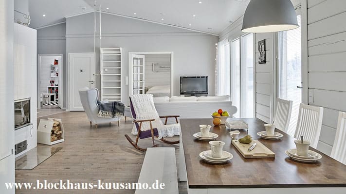 Wohnzimmer mit Kaminofen und Fernsehecke im Massivholzhaus - Holzhäuser in Baden-Württemberg - Blockhaus-Kuusamo.de 