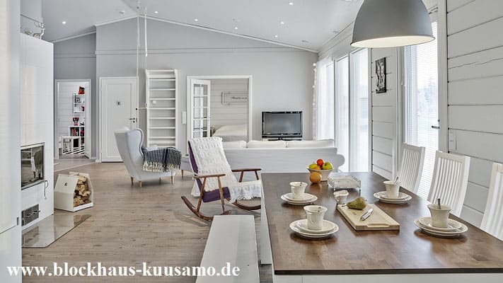 Wohnzimmer mit Kaminofen und Fernsehecke im Massivholzhaus  -  Blockhaus-Kuusamo.de 