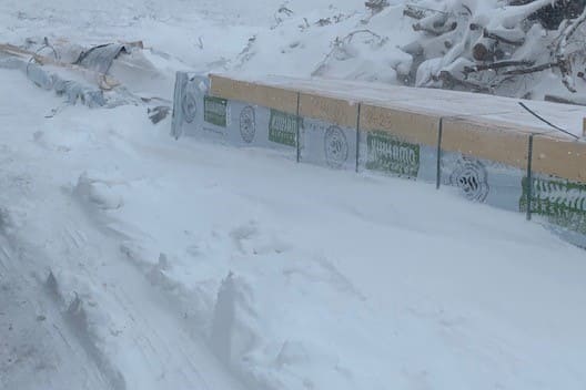 Baustelle - Bauen im Winter - Baumaterial - Schnee - Schneesturm - Holz - Holzpakete - Bausatz - Bündel - Bayern - Deutschland 