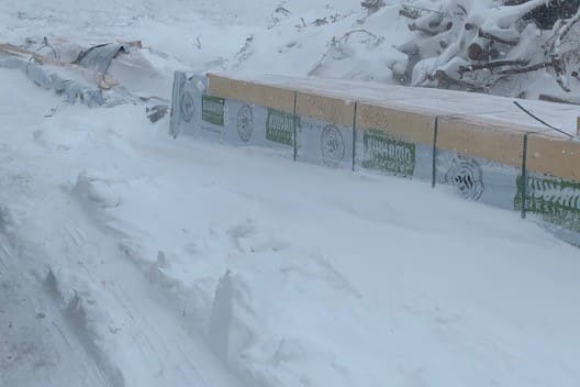 Baustelle - Bauen im Winter - Baumaterial - Schnee - Schneesturm - Holz - Holzpakete - Bausatz - Bündel - Bayern - Deutschland  