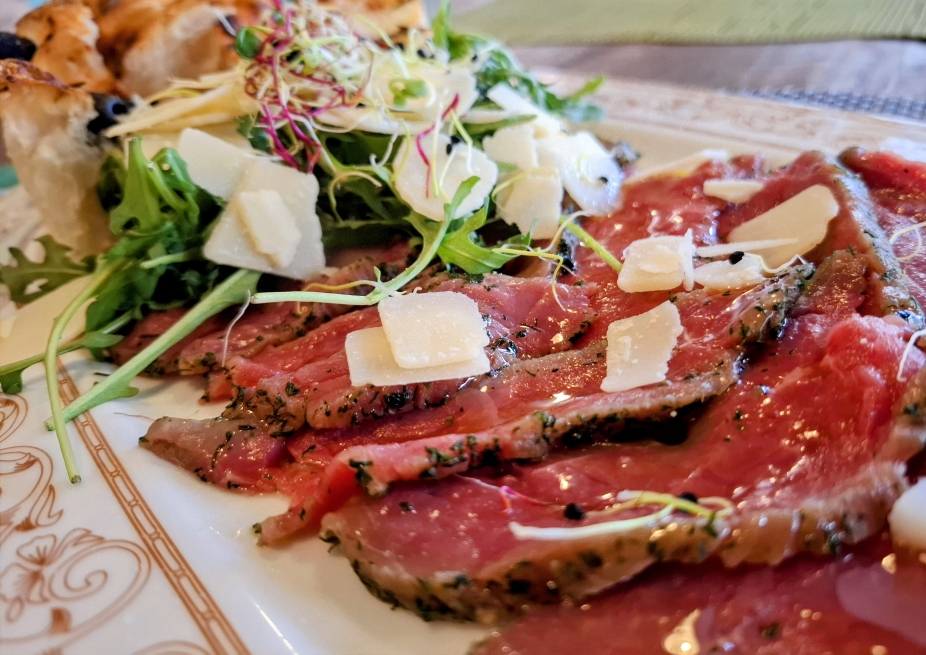 Hausgemachtes Rindscarpaccio mit Kräutern mariniert, Handgeschnitten, mit Ruccola, Parmesan und frischer Focaccia