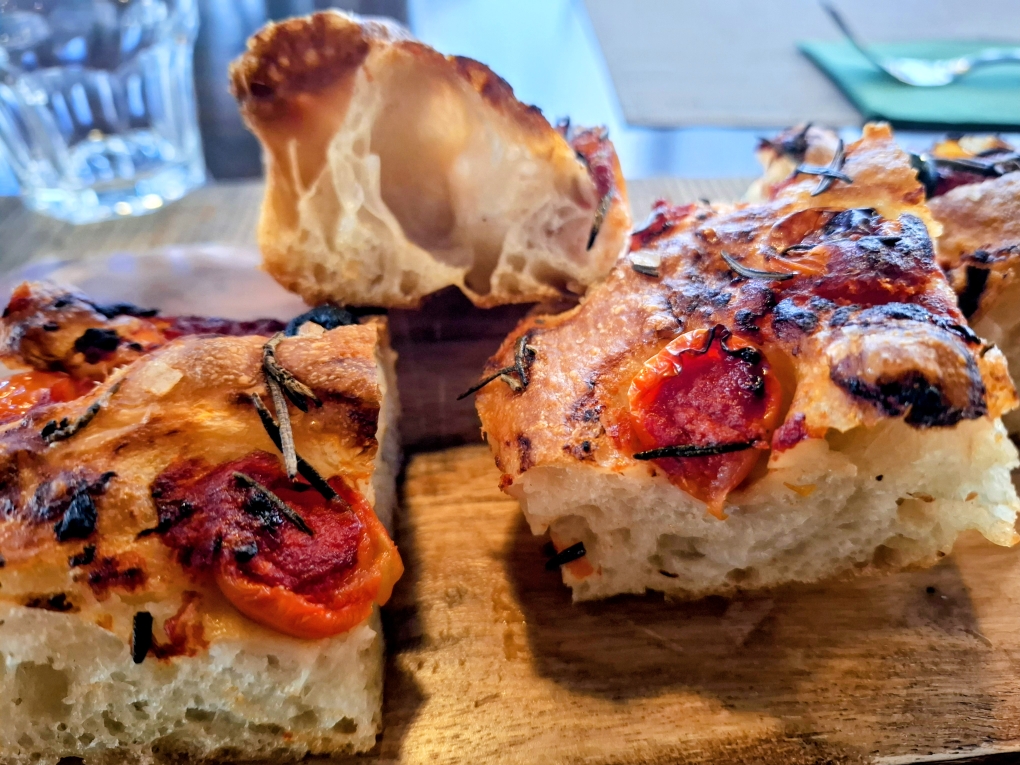 Hausgemachte Focaccia mit Tomaten, Oliven, Rosmarin, Meersalz